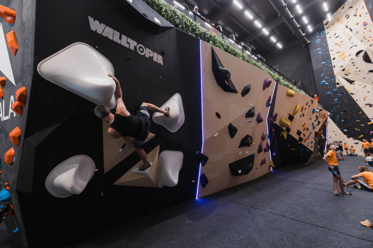 Walltopia boulder climbing walls featuring natural wood and solid color panels,LED stripes and a boulder problem set with Walltopia thermoplastic volumes range The Nose.