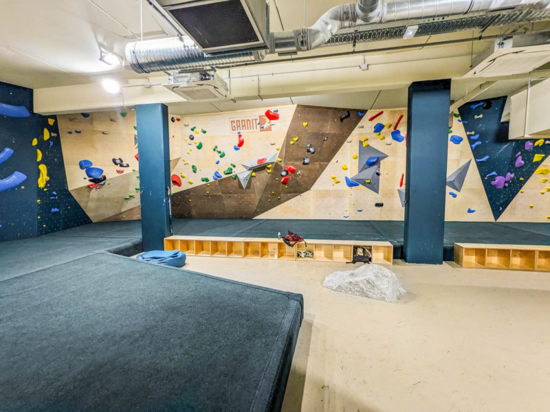 Walltopia boulder climbing walls in Granit Climb, France. Natural wood climbing panels combined with natural stone climbing panels and solid grey panels. Climbmat boulder mats.