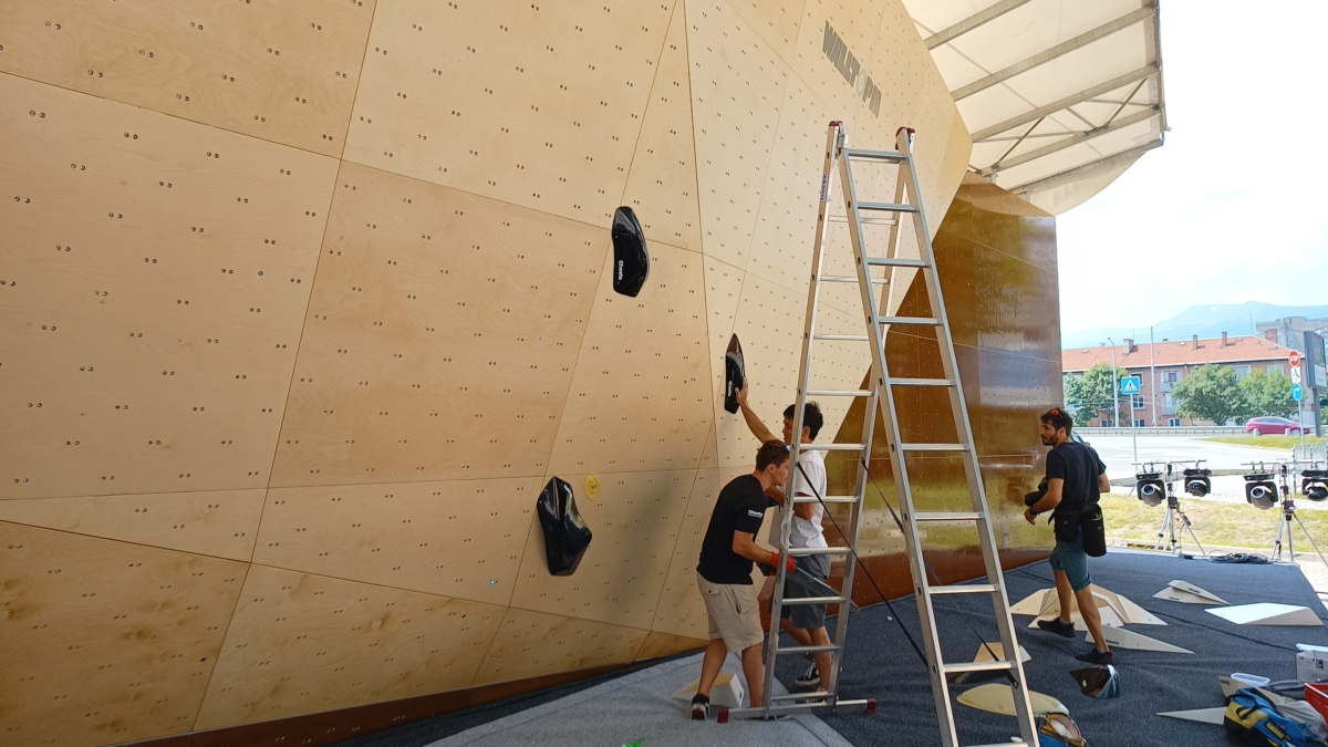 Climbers and routesetter in front of the natural wood boulder during Set & Send Boulder Comp in Sofia, Bulgaria